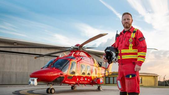 Photo of a critical care paramedic next to Cornwall Air Ambulance helicopter