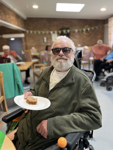 resident at coffee morning with a slice of fruit cake