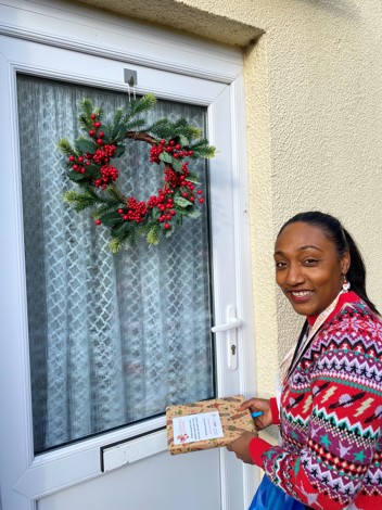 A housing officer delivering a parcel to a resident
