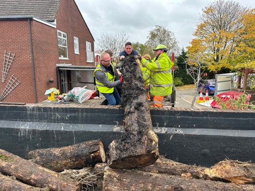 Cornwall Housing Estate rangers unloading logs from a lorry to fill up the space left by an empty fishpond