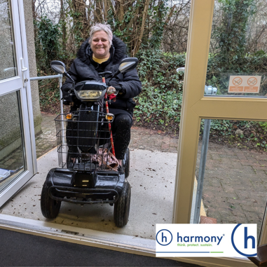 Photo of a lady using the accessibility ramp on her mobility scooter