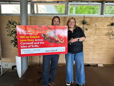 Cornwall Housing Managing Director presenting a cheque for £11,726.42 to a representative from the Cornwall Air Ambulance Trust.