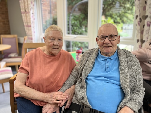 two residents, seated, at a coffee morning